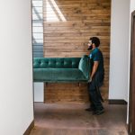 Professional movers carefully disassemble a heavy pool table in a residential game room before a local move.