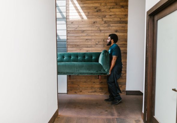 Professional movers carefully disassemble a heavy pool table in a residential game room before a local move.